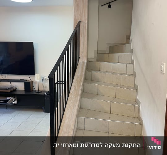 גרם מדרגות עם מעקה מתכת וטלוויזיה בסלון